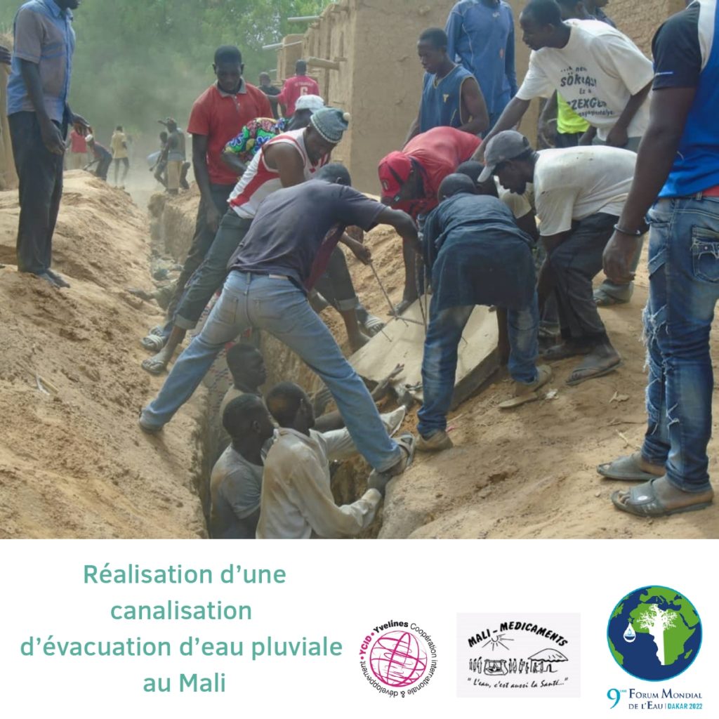 Photo : groupe d'hommes maliens qui participent à la réalisation d'une canalisation d'évacuation d'eau pluviale au Mali.