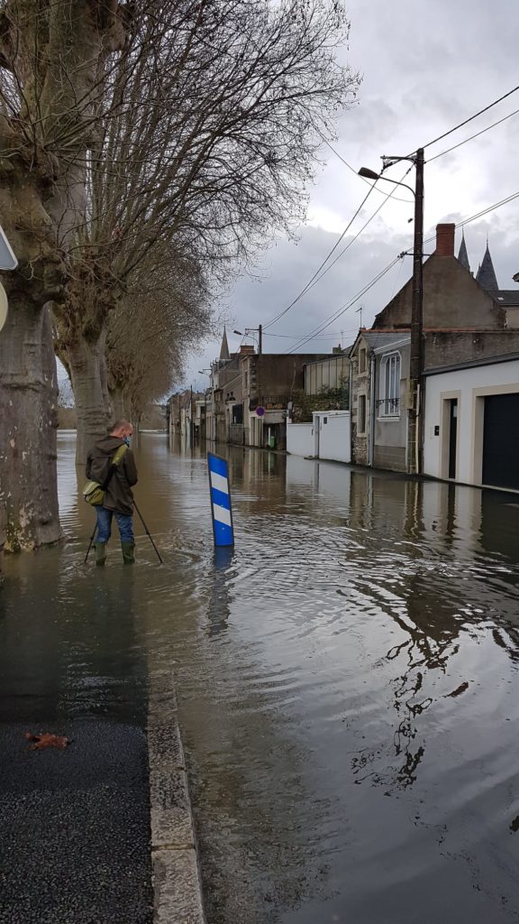 Ville de Challones sur Loire, une rue est inondée, une personne marche les pieds dans l'eau.