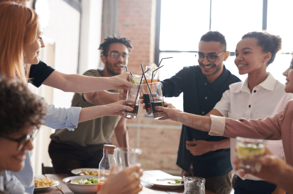 des amis trinquent ensemble au dessus d'une table