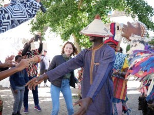 Groupe de personnes qui dansent en costumes traditionnels sénégalais et camerounais 