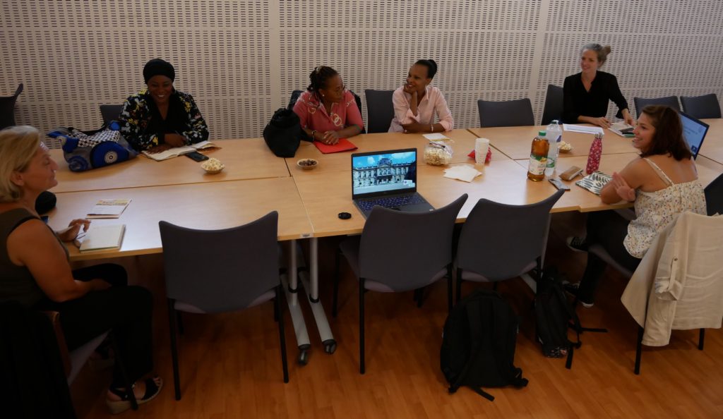 Des femmes, membres d'YCID, assises à une table de réunion
