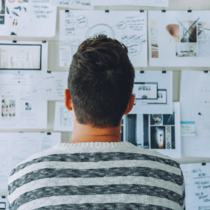 un homme regarde un tableau avec des graphiques pour concevoir son projet
