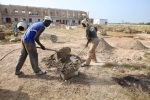 Deux hommes sénégalais construisent un bâtiment pour une école