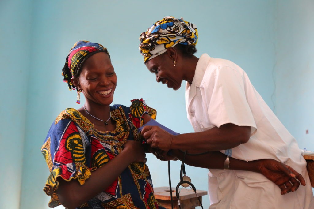 Photo : 2 femmes maliennes, une infirmière prend la tension d'une patiente.