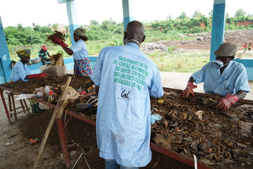Deux hommes et deux femmes contrôles les déchets solides ménagers à Comé au Bénin.